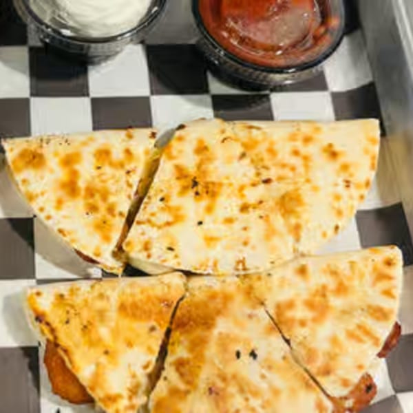 Endzone Bar & Grill quesadilla slices with dipping sauces on a checkered paper liner.