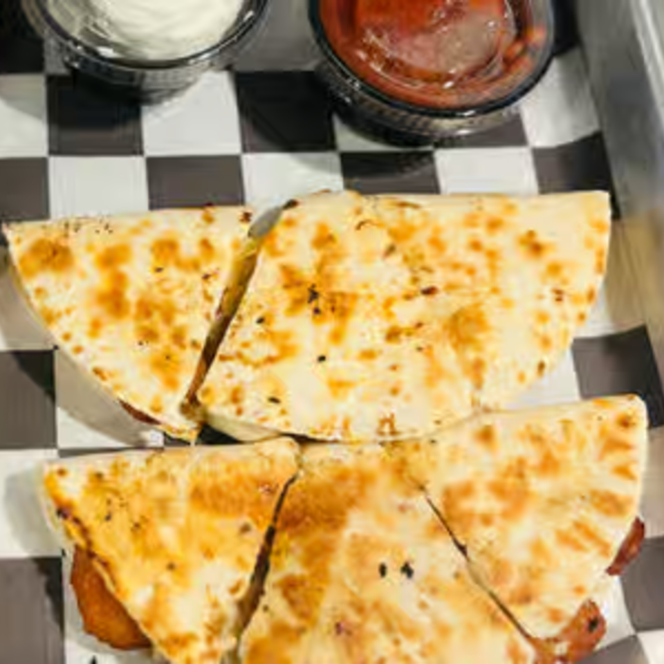 Endzone Bar & Grill quesadilla slices with dipping sauces on a checkered paper liner.