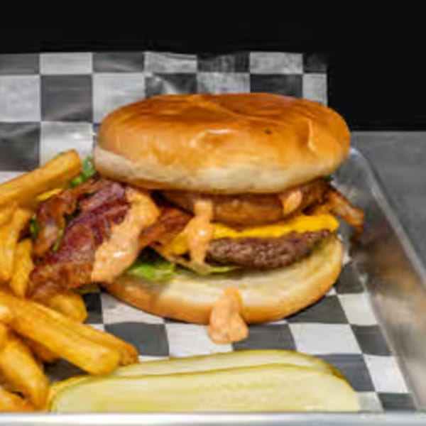 Endzone Bar & Grill's bacon cheeseburger with fries and a pickle spear on a checkered tray.